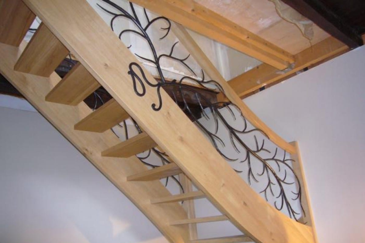 escalier et rampe en bois avec des détails noir en fer forgé